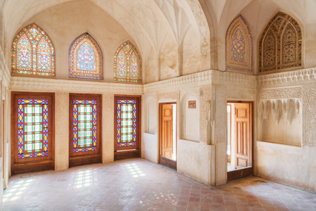 Kashan, Iran - 21 October, 2018: Wonderful room inside the Abbasi Historical House. Beautiful view of traditional colorful Iranian stained glass windows. Persian interior. Amazing play of light.のeditorial素材