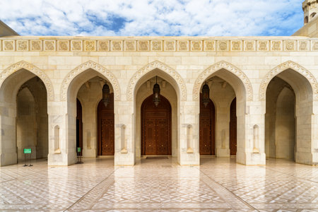 Muscat, Oman - 17 October, 2018: Beautiful arched gates and carved wooden doors leading to the Sultan Qaboos Grand Mosque. The Muslim place is a popular tourist attraction of the Middle East.のeditorial素材