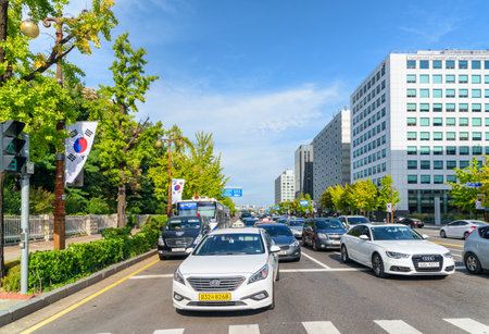 Seoul, South Korea - October 14, 2017: Day traffic of Yeouido. The flag of South Korea fluttering over road. Yeoui Island is the main finance and investment banking district of Seoul. Scenic cityscapeのeditorial素材