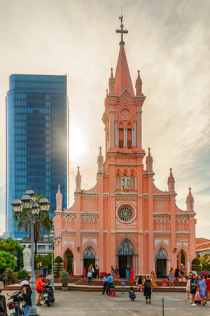 Da Nang (Danang), Vietnam - April 15, 2018: Evening view of Da Nang Cathedral. Visitors taking pictures on the church background. The Pink Catholic Church is a popular tourist attraction of Asia.のeditorial素材