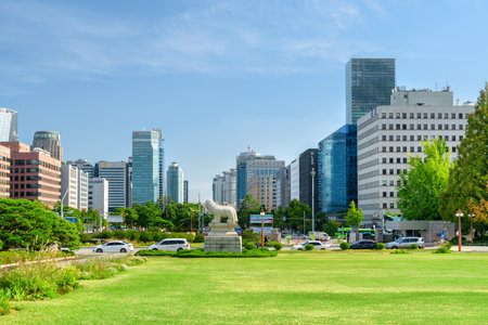 Seoul, South Korea - October 14, 2017: View of green lawn in front of the National Assembly Proceeding Hall at Yeouido (Yeoui Island). Skyscrapers and other modern buildings on blue sky background.のeditorial素材