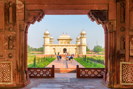 Agra, India - 9 November, 2018: Unusual view of the Tomb of Itimad-ud-Daulah (Baby Taj) through red sandstone gate. The white marble mausoleum is a popular tourist attraction of South Asia.のeditorial素材