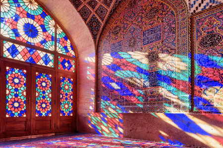 Awesome view of morning sunlight reflected through colorful stained glass window on the wall and the floor of prayer hall at the Nasir al-Mulk Mosque (Pink Mosque) in Shiraz, Iran. Persian interior.のeditorial素材