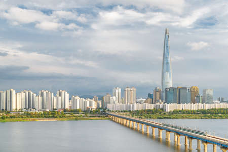 Amazing view of skyscraper at downtown of Seoul in South Korea on cloudy sky background. Scenic modern tower and Jamsil Railway Bridge over the Han River (Hangang). Wonderful cityscape.の写真素材