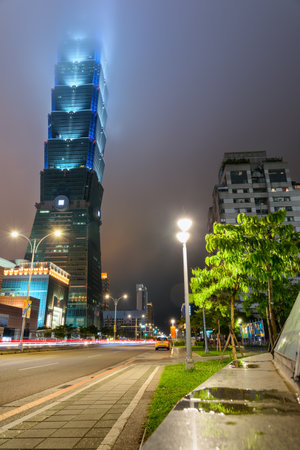 Taipei, Taiwan - April 27, 2019: Fabulous night view of Taipei 101 (Taipei World Financial Center) disappearing in fog. The tower is a supertall skyscraper and a landmark of Taiwan. Awesome cityscape.のeditorial素材
