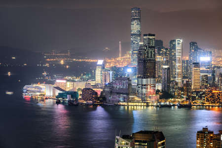Amazing night aerial view of Victoria Harbor and Hong Kong. Awesome cityscape. Hong Kong is a popular tourist destination of Asia.の写真素材