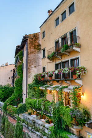Beautiful balconies of old house decorated with plants in pots, Verona, Italy. Verona is a popular tourist destination of Europe.の写真素材