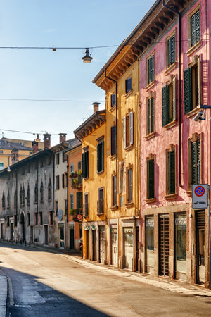 Verona, Italy - August 24, 2014: View of narrow street at historic centre of Verona, Italy. Facades of houses in morning sun. Verona is a popular tourist destination of Europe.のeditorial素材