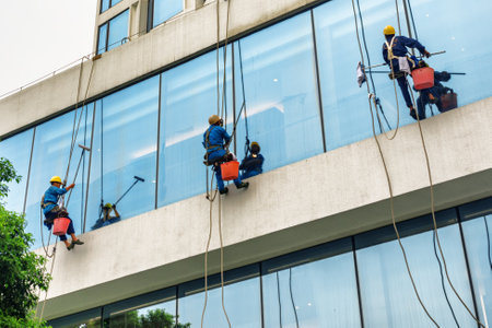 Guangzhou, China - November 7, 2015: Industrial climbers are cleaning windows of high-rise building. Guangzhou is a popular tourist destination of Asia.のeditorial素材
