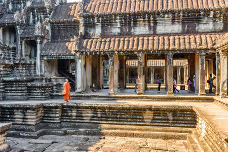 Siem Reap, Cambodia - May 4, 2015: Buddhist monk walking at courtyard of ancient temple complex Angkor Wat. Amazing Angkor Wat is a popular destination of tourists and pilgrims.のeditorial素材