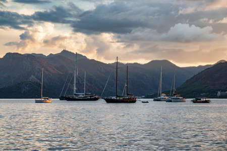 Sunset view of yachts crossing Marmaris Harbor, Turkey. The port city is a popular tourist destination in the Turkish Riviera.の写真素材