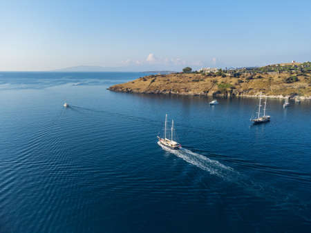 Aerial view of a white yacht crossing Bodrum Harbor. The port city is a popular tourist destination in the Turkish Riviera.の写真素材