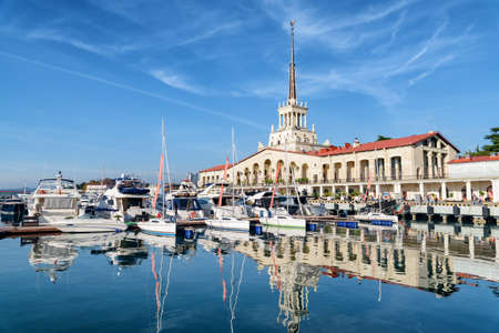 View of the Commercial Sea Port of Sochi. The building of Marine passenger terminal reflected in water. The seaport on the Black Sea is a popular tourist attraction.の写真素材