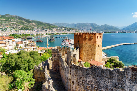 Awesome view of the Kizil Kule (Red Tower) from fortress walls of Alanya Castle in Turkey. The Mediterranean Sea is visible in background. The octagonal red brick tower is a popular tourist attractionのeditorial素材