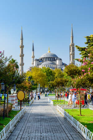 Awesome view of the Sultan Ahmed Mosque (the Blue Mosque) among green gardens. Tourists and residents rest and walk along scenic city park.の写真素材