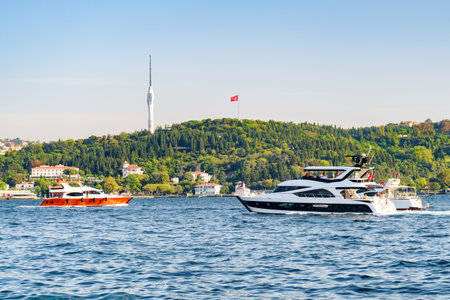 Speedboats are crossing the Bosporus in Istanbul, Turkey. The Camlica Tower is visible in background. Istanbul is a popular tourist destination in the world.の写真素材