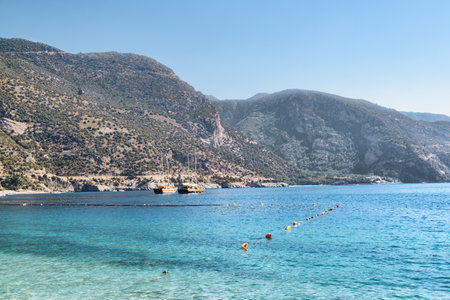 View of wonderful clear water of the Mediterranean Sea from Oludeniz Beach in Turkey. Scenic mountains are visible in background. Oludeniz is a popular tourist attraction in Turkey.の写真素材