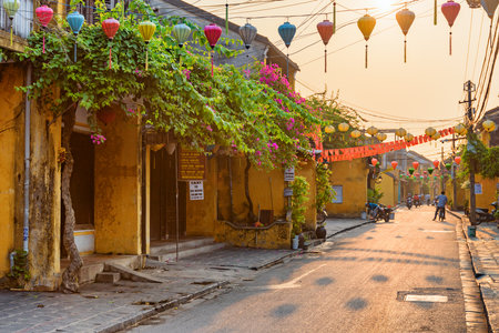Hoi An (Hoian), Vietnam - April 12, 2018: Scenic cozy street decorated with colorful silk lanterns at sunrise. Awesome traditional old yellow houses of Hoi An Ancient Town.のeditorial素材