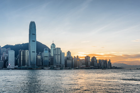 Hong Kong - View of Hong Kong Island skyline across Victoria harbor at sunset. Amazing cityscape. Hong Kong is a popular tourist destination of Asia.の写真素材