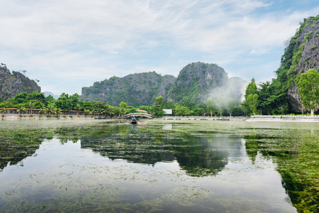 Awesome view of natural karst towers reflected in water of the Ngo Dong River at the Tam Coc portion, Ninh Binh Province, Vietnam. The Tam Coc is a popular tourist attraction in Asia.の写真素材