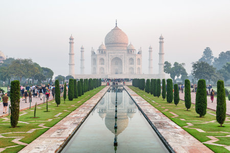 The Taj Mahal at morning time in Agra, India. The white marble mausoleum reflected in artificial pool. The Taj Mahal is a popular tourist attraction of South Asia.の写真素材