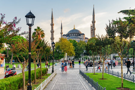 Awesome view of the Sultan Ahmed Mosque (the Blue Mosque) among green gardens. Tourists and residents rest and walk along scenic city park.の写真素材