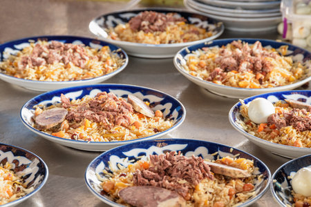 Fresh cooked wedding Uzbek plov in Tashkent, Uzbekistan. The signature dish of Uzbekistan is cooked with rice, meat, carrots and onions. Pilaf is a traditional food at Central Asia.の写真素材