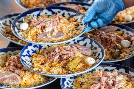 Fresh cooked wedding Uzbek plov in Tashkent, Uzbekistan. The signature dish of Uzbekistan is cooked with rice, meat, carrots and onions. Pilaf is a traditional food at Central Asia.の写真素材