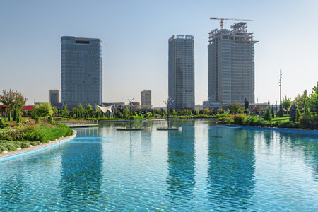 Awesome view of contemporary buildings reflected in pool of Tashkent City Park in Tashkent, Uzbekistan. The park is a popular recreational gathering place among residents and tourists.の写真素材
