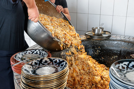 Fresh cooked wedding Uzbek plov in Tashkent, Uzbekistan. The signature dish of Uzbekistan is cooked with rice, meat, carrots and onions. Pilaf is a traditional food at Central Asia.の写真素材