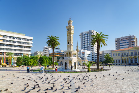 Izmir, Turkey - October 26, 2021: Scenic view of Izmir Clock Tower in the middle of Konak Square and a flock of pigeons. The tower is the landmark of the port city.のeditorial素材