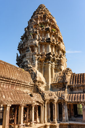 Upper gallery and one of towers at main Temple Mountain of ancient temple complex Angkor Wat in Siem Reap, Cambodia. Angkor Wat is a popular tourist attraction.の写真素材