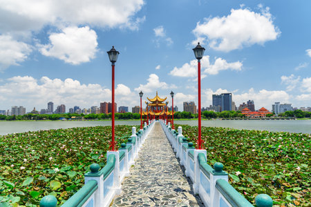 Awesome view of bridge leading to Wuliting at Lotus Lake in Kaohsiung, Taiwan. The traditional Chinese red pavilion with golden roof is a popular tourist attraction of Asia.の写真素材