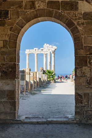 Awesome view of the Temple of Apollo through arch gate of Byzantine Basilica on the Mediterranean Sea coast in Side, Turkey. Ruins of the Roman temple are a popular tourist attraction in Turkey.の写真素材