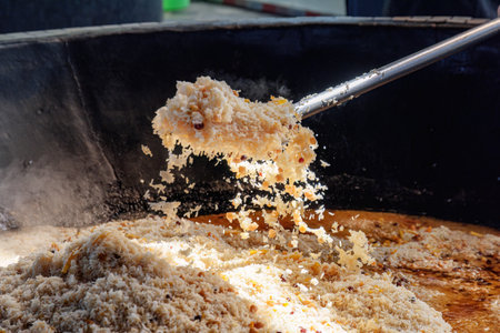 Uzbek plov (pilaf) is being prepared in giant kazan, Tashkent, Uzbekistan. The signature dish of Uzbekistan is cooked with rice, meat, carrots and onions. Pilaf is a traditional food at Central Asia.の写真素材