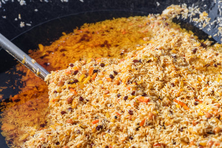 Fresh cooked wedding Uzbek plov in giant kazan, Tashkent, Uzbekistan. The signature dish of Uzbekistan is cooked with rice, meat, carrots and onions. Pilaf is a traditional food at Central Asia.の写真素材