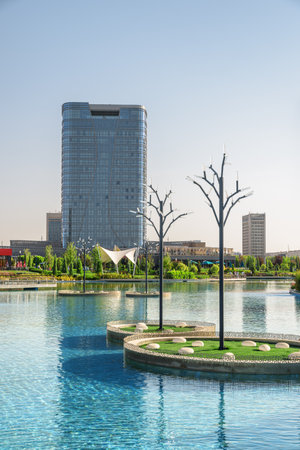 Awesome view of contemporary buildings reflected in pool of Tashkent City Park in Tashkent, Uzbekistan. The park is a popular recreational gathering place among residents and tourists.の写真素材
