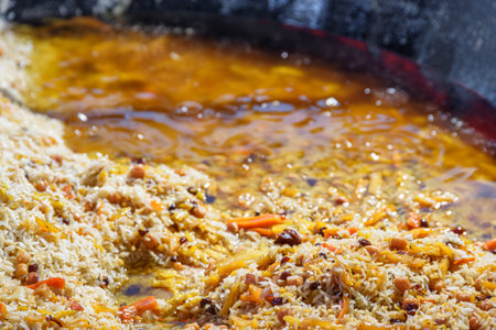 Fresh cooked wedding Uzbek plov in giant kazan, Tashkent, Uzbekistan. The signature dish of Uzbekistan is cooked with rice, meat, carrots and onions. Pilaf is a traditional food at Central Asia.の写真素材
