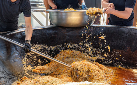 Uzbek plov (pilaf) is being prepared in giant kazan, Tashkent, Uzbekistan. The signature dish of Uzbekistan is cooked with rice, meat, carrots and onions. Pilaf is a traditional food at Central Asia.の写真素材