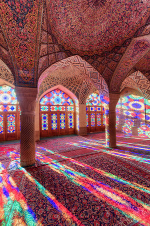 Shiraz, Iran - 31 October, 2018: Colorful view of morning sunlight reflected through stained glass windows on columns, the wall and the floor of prayer hall at the Nasir al-Mulk Mosque (Pink Mosque).のeditorial素材