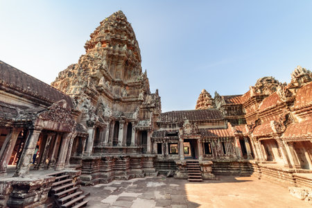 Upper gallery and one of towers at main Temple Mountain of ancient temple complex Angkor Wat in Siem Reap, Cambodia. Angkor Wat is a popular tourist attraction.の写真素材