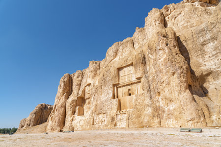 Awesome ancient necropolis Naqsh-e Rustam on blue sky background in Iran. Large tombs belonging to Achaemenid kings carved out of rock face at considerable height above the ground.の写真素材
