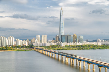 View of Jamsil Railway Bridge over the Han River (Hangang) at downtown of Seoul in South Korea. Skyscraper is visible on cloudy sky background. Beautiful cityscape.の写真素材