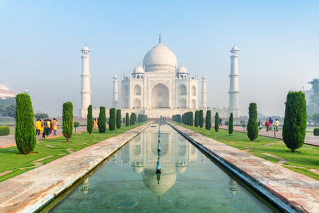 The Taj Mahal at morning time in Agra, India. The white marble mausoleum reflected in artificial pool. The Taj Mahal is a popular tourist attraction of South Asia.の写真素材