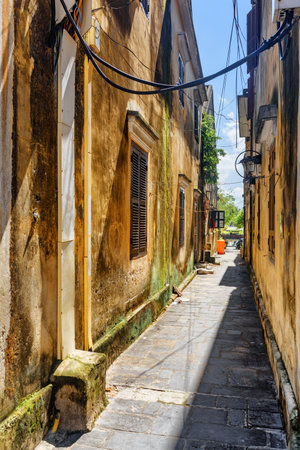 Morning view of cozy narrow street in Hoi An, Vietnam. Scenic traditional old yellow house. Hoi An Ancient Town is a popular tourist destination of Asia.の写真素材