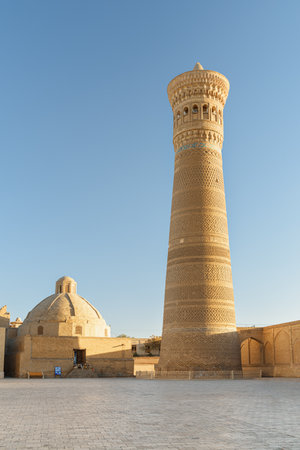 Awesome view of the Kalan Minaret of Po-i-Kalan complex in Bukhara, Uzbekistan. The ancient circular-pillar baked brick tower is a popular tourist attraction of Central Asia.の写真素材