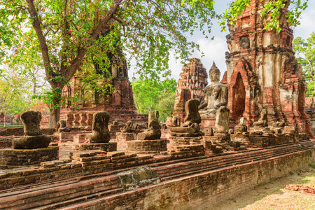 Buddha statue among ruins of the Wat Mahathat in Ayutthaya, Thailand. Amazing view of the Buddhist temple in the ancient city of the Ayutthaya Kingdom (Siam). Thailand is a popular tourist destinationの写真素材