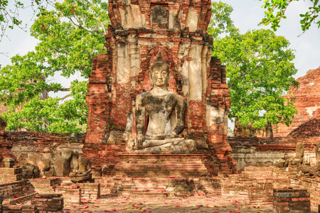 Buddha statue among ruins of the Wat Mahathat in Ayutthaya, Thailand. Amazing view of the Buddhist temple in the ancient city of the Ayutthaya Kingdom (Siam). Thailand is a popular tourist destinationの写真素材