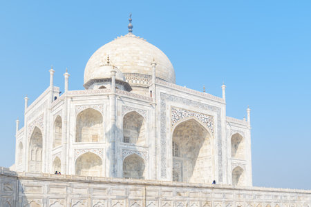Awesome view of the Taj Mahal on blue sky background in Agra, India. The white marble mausoleum is a popular tourist attraction of South Asia.の写真素材