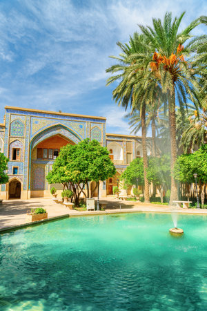 Fabulous fountain in the middle of traditional Persian courtyard with green garden at Madrese e-Khan in Shiraz, Iran. The ancient religious school is a popular tourist attraction of the Middle East.の写真素材